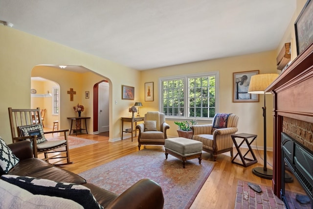 203 W 21st Ave, Spokane, WA 99203 - living room featuring arched walkways, a brick fireplace, and light wood-style flooring
