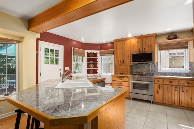 203 W 21st Ave, Spokane, WA 99203 - kitchen featuring stainless steel appliances, tile countertops, decorative backsplash, brown cabinetry, and open shelves