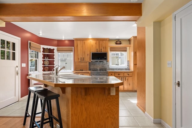 203 W 21st Ave, Spokane, WA 99203 - kitchen with stainless steel appliances, light tile patterned floors, a breakfast bar, backsplash, and tile counters