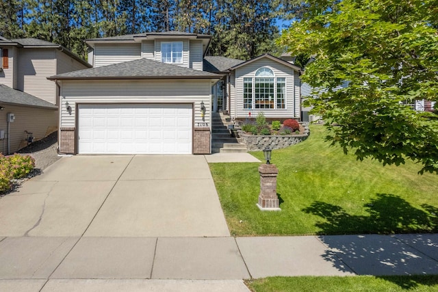 7106 S Moran View St, Spokane, WA 99224 - view of front of home with brick siding, a garage, a front lawn, and concrete driveway