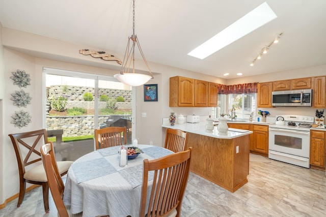 7106 S Moran View St, Spokane, WA 99224 - kitchen with electric stove, stainless steel microwave, a skylight, a peninsula, and light countertops