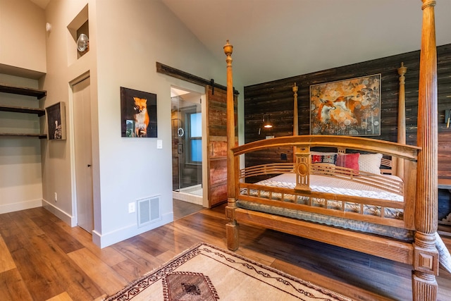 210 3rd St, Dover, ID 83825 - bedroom with a barn door, wood finished floors, and vaulted ceiling