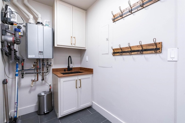 210 3rd St, Dover, ID 83825 - laundry area with tankless water heater, dark tile patterned floors, and electric panel
