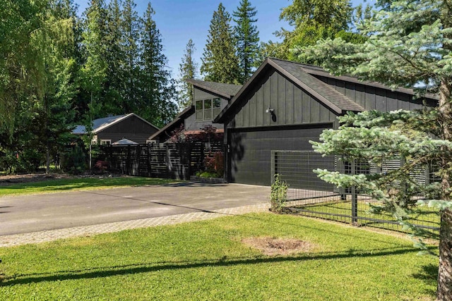 210 3rd St, Dover, ID 83825 - view of home's exterior with board and batten siding, driveway, a garage, and a shingled roof