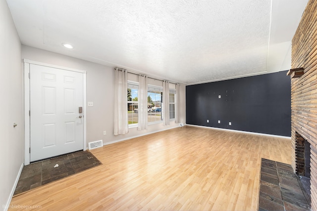 11918 E Grace Ave, Spokane Valley, WA 99206 - unfurnished living room with a fireplace, a textured ceiling, wood finished floors, and recessed lighting
