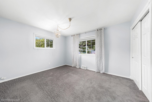 11918 E Grace Ave, Spokane Valley, WA 99206 - unfurnished bedroom featuring multiple windows, a chandelier, carpet, and a closet