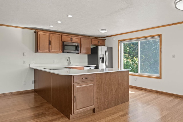 214 W 6th Ave Apt 201, Spokane, WA 99204 - kitchen with stainless steel appliances, a peninsula, light wood-style floors, light countertops, and crown molding