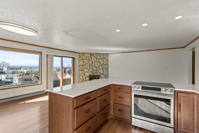 214 W 6th Ave Apt 201, Spokane, WA 99204 - kitchen with electric range, wood finished floors, light countertops, a fireplace, and brown cabinetry