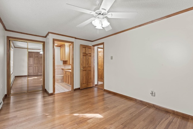 214 W 6th Ave Apt 201, Spokane, WA 99204 - unfurnished bedroom with light wood-style floors, a textured ceiling, ornamental molding, a ceiling fan, and connected bathroom