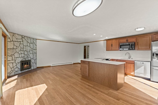 214 W 6th Ave Apt 201, Spokane, WA 99204 - kitchen with appliances with stainless steel finishes, baseboard heating, light wood-style flooring, light countertops, and crown molding