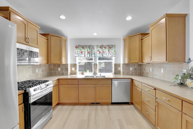 1707 E Vanetta Ave, Spokane, WA 99217 - kitchen featuring appliances with stainless steel finishes, light countertops, decorative backsplash, light brown cabinets, and light wood-type flooring