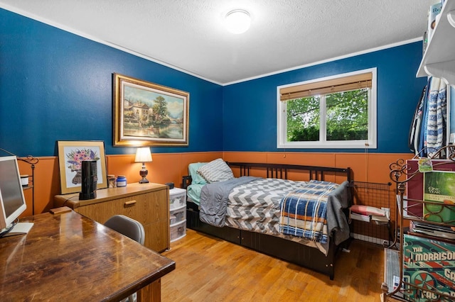 6204 N Oxford Dr, Spokane, WA 99208 - bedroom with light wood-style floors, a textured ceiling, crown molding, and a wainscoted wall