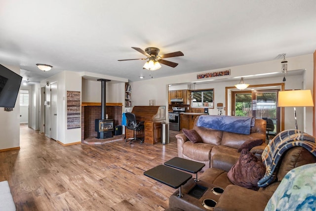 6204 N Oxford Dr, Spokane, WA 99208 - living room with a wood stove, a ceiling fan, healthy amount of natural light, and light wood finished floors