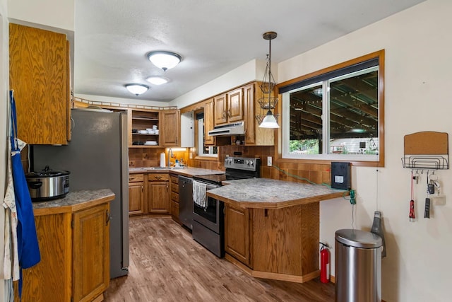 6204 N Oxford Dr, Spokane, WA 99208 - kitchen featuring appliances with stainless steel finishes, brown cabinetry, light wood-type flooring, under cabinet range hood, and open shelves