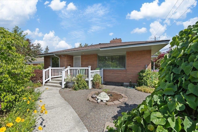 3157 E 35th Ave, Spokane, WA 99223 - view of front of home with brick siding, a chimney, and an outdoor fire pit