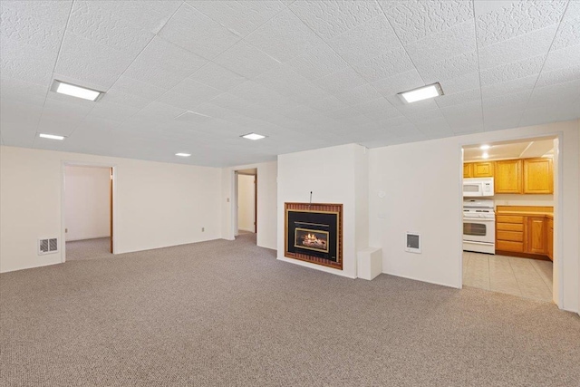 3157 E 35th Ave, Spokane, WA 99223 - unfurnished living room with light carpet and a lit fireplace