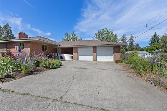 3157 E 35th Ave, Spokane, WA 99223 - single story home with brick siding, an attached garage, a chimney, and driveway