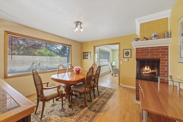 3157 E 35th Ave, Spokane, WA 99223 - dining room featuring healthy amount of natural light, light wood-style flooring, and a brick fireplace