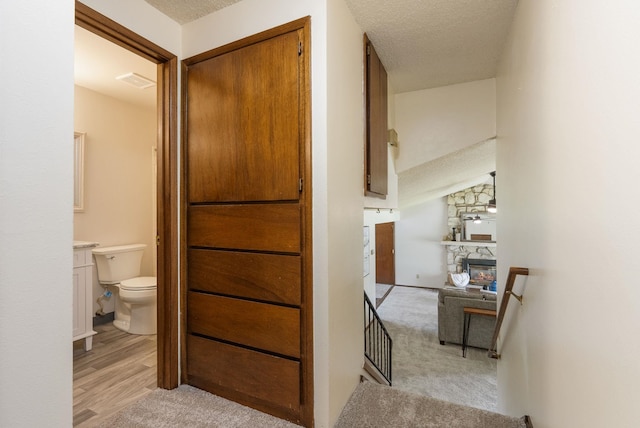 10818 N Humboldt Dr, Spokane, WA 99218 - corridor featuring a textured ceiling, light carpet, and light wood finished floors
