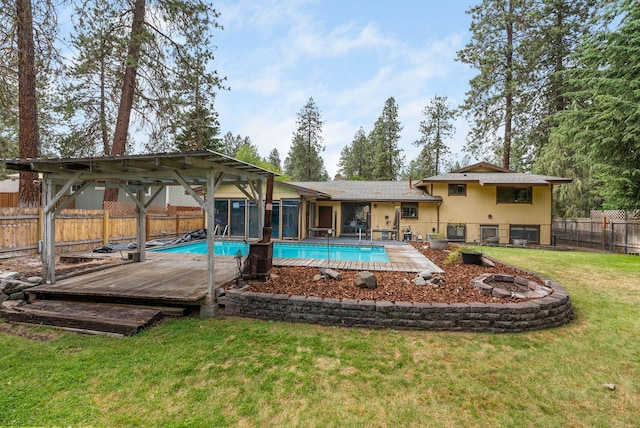 10818 N Humboldt Dr, Spokane, WA 99218 - view of swimming pool featuring a fenced backyard, a sunroom, a wooden deck, and an outdoor fire pit