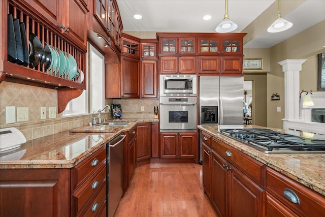2008 S Zephyr Rd, Liberty Lake, WA 99019 - kitchen featuring stainless steel appliances, pendant lighting, light wood-style flooring, backsplash, and light stone countertops