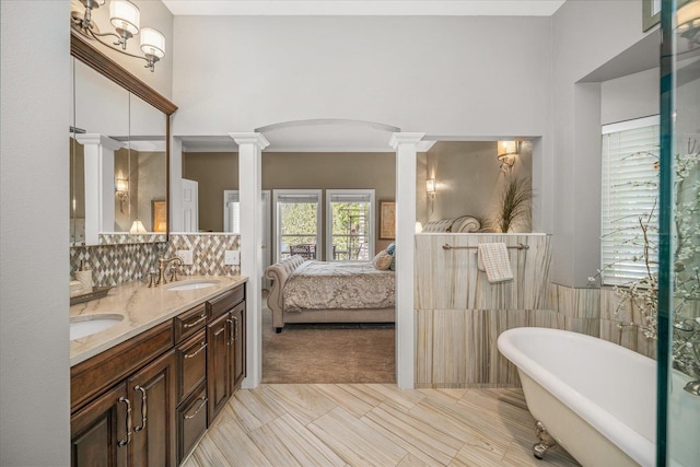 2008 S Zephyr Rd, Liberty Lake, WA 99019 - full bathroom with decorative columns, double vanity, a freestanding bath, connected bathroom, and decorative backsplash