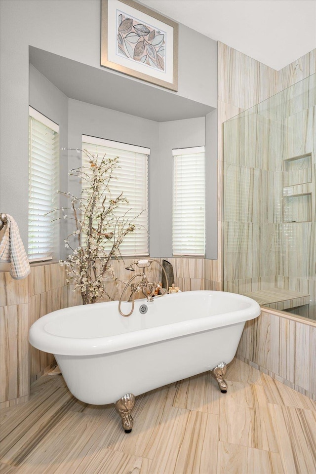 2008 S Zephyr Rd, Liberty Lake, WA 99019 - bathroom featuring tile walls, a soaking tub, plenty of natural light, and wainscoting
