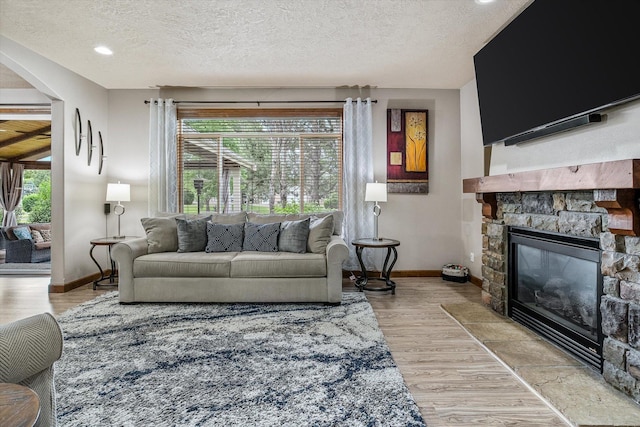 2813 S Steen Ln, Greenacres, WA 99016 - living room with arched walkways, a textured ceiling, a stone fireplace, and wood finished floors