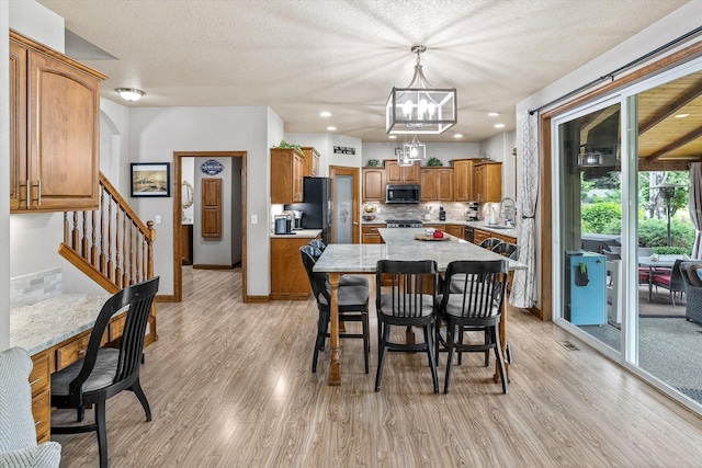 2813 S Steen Ln, Greenacres, WA 99016 - dining room featuring a chandelier, light wood finished floors, stairway, a textured ceiling, and recessed lighting