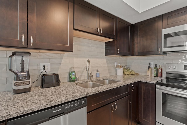 419 E E St, Deer Park, WA 99006 - kitchen featuring stainless steel appliances, backsplash, dark brown cabinetry, and light stone counters