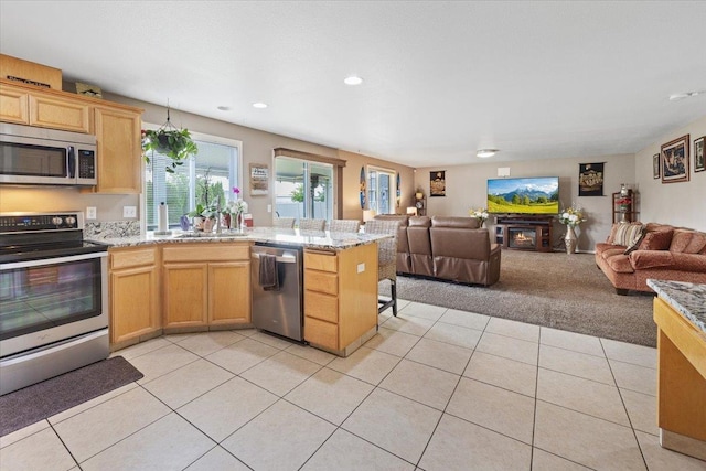 9713 W Sage Ct, Cheney, WA 99004 - kitchen featuring stainless steel appliances, open floor plan, light tile patterned floors, a peninsula, and light carpet