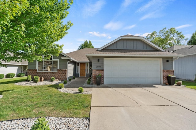2808 E 62nd Ln, Spokane, WA 99223 - view of front of home featuring brick siding, concrete driveway, an attached garage, and a front yard