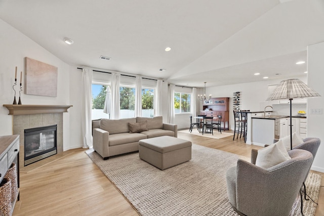2808 E 62nd Ln, Spokane, WA 99223 - living area with lofted ceiling, light wood finished floors, a fireplace, a chandelier, and recessed lighting