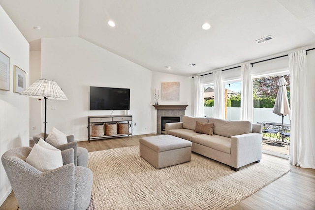 2808 E 62nd Ln, Spokane, WA 99223 - living room featuring wood finished floors, vaulted ceiling, recessed lighting, and a tile fireplace