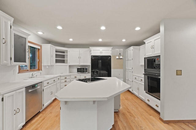 13419 N Whitehouse Ct, Spokane, WA 99208 - kitchen featuring black appliances, a kitchen island, white cabinets, light wood-style flooring, and recessed lighting