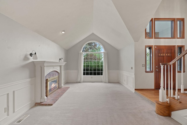 13419 N Whitehouse Ct, Spokane, WA 99208 - unfurnished living room featuring a decorative wall, carpet flooring, wainscoting, stairway, and vaulted ceiling