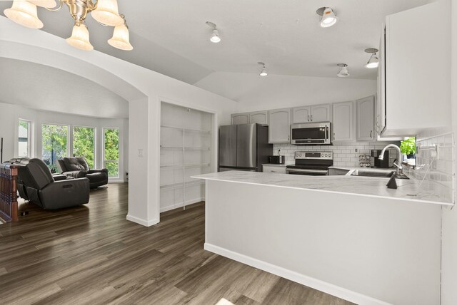 18108 E Crescent Dr, Greenacres, WA 99016 - kitchen with appliances with stainless steel finishes, vaulted ceiling, decorative backsplash, light countertops, and a peninsula