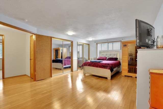 4319 S Myrtle St, Spokane, WA 99223 - bedroom featuring two closets, light wood-type flooring, and a textured ceiling