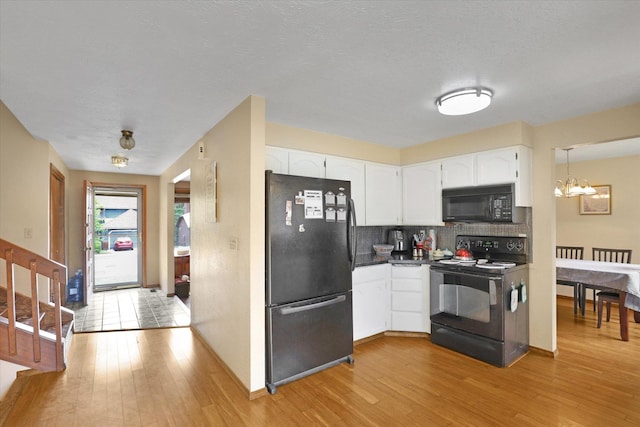 4319 S Myrtle St, Spokane, WA 99223 - kitchen with black appliances, a chandelier, decorative backsplash, light wood-style flooring, and a textured ceiling