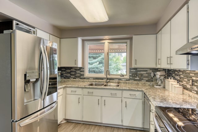 1026 W Bellwood Dr, Spokane, WA 99218 - kitchen featuring appliances with stainless steel finishes, tasteful backsplash, light wood-type flooring, and white cabinets