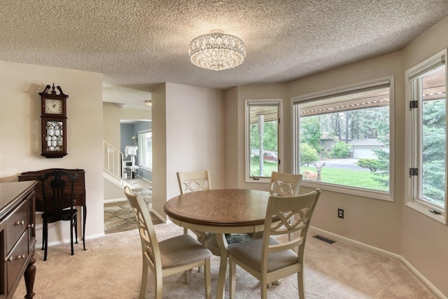 1026 W Bellwood Dr, Spokane, WA 99218 - dining area with light carpet, a textured ceiling, healthy amount of natural light, and a chandelier