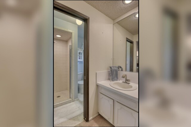1026 W Bellwood Dr, Spokane, WA 99218 - full bathroom featuring vanity, a textured ceiling, a shower stall, tile patterned flooring, and recessed lighting