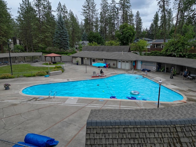 1026 W Bellwood Dr, Spokane, WA 99218 - community pool featuring a patio area and view of scattered trees