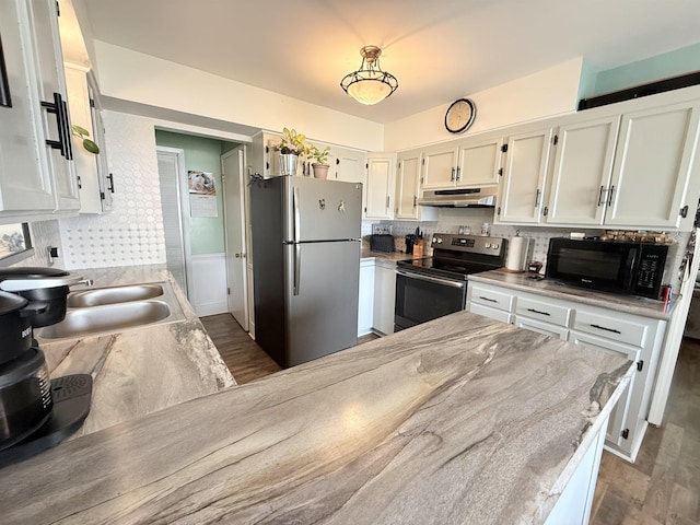 1710 E Crown Ave, Spokane, WA 99207 - kitchen with stainless steel appliances, under cabinet range hood, decorative backsplash, and wood finished floors