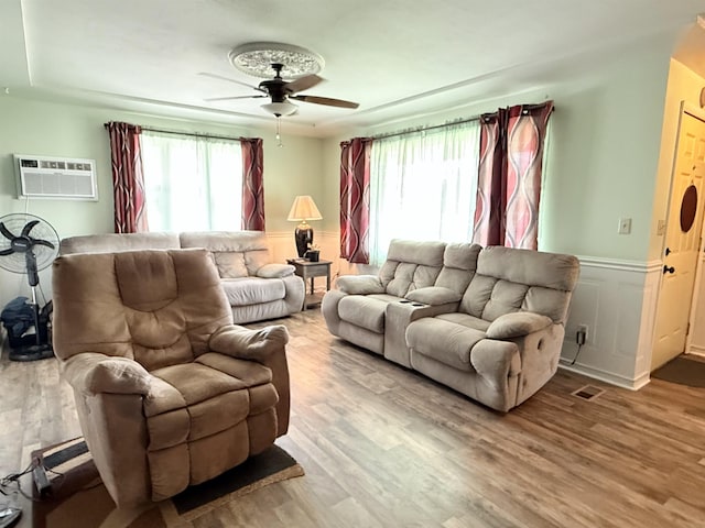 1710 E Crown Ave, Spokane, WA 99207 - living area featuring an AC wall unit, a ceiling fan, wood finished floors, and wainscoting