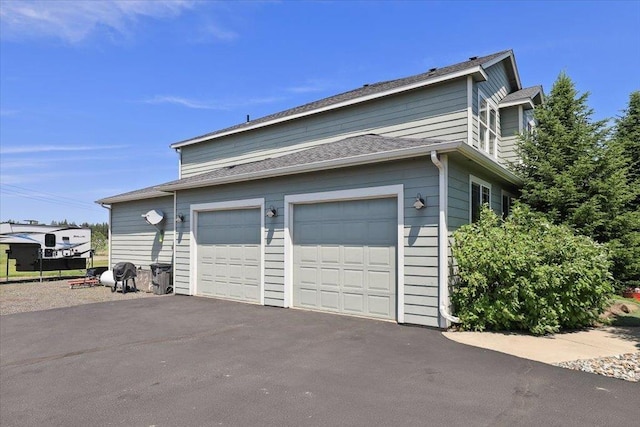 1716 W Country Hunt Ln, Spokane, WA 99224 - view of side of property with asphalt driveway and an attached garage