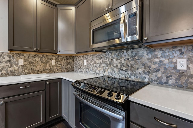 2121 W Bridge Ave Unit 2121, Spokane, WA 99201 - kitchen with stainless steel microwave, range with electric cooktop, light countertops, and backsplash