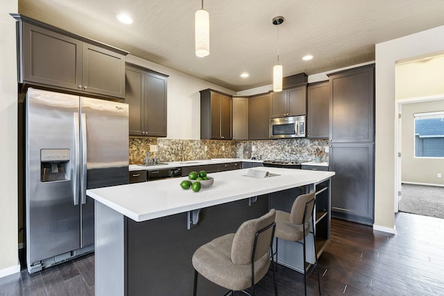 2121 W Bridge Ave Unit 2121, Spokane, WA 99201 - kitchen featuring appliances with stainless steel finishes, tasteful backsplash, a kitchen island, dark wood-type flooring, and recessed lighting