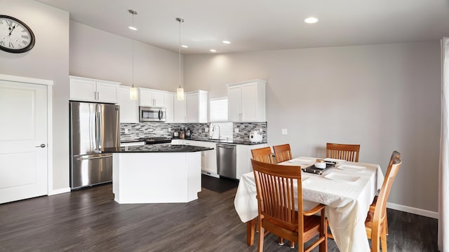 5710 S Ravencrest Dr, Spokane, WA 99224 - kitchen featuring stainless steel appliances, decorative backsplash, a kitchen island, white cabinetry, and high vaulted ceiling