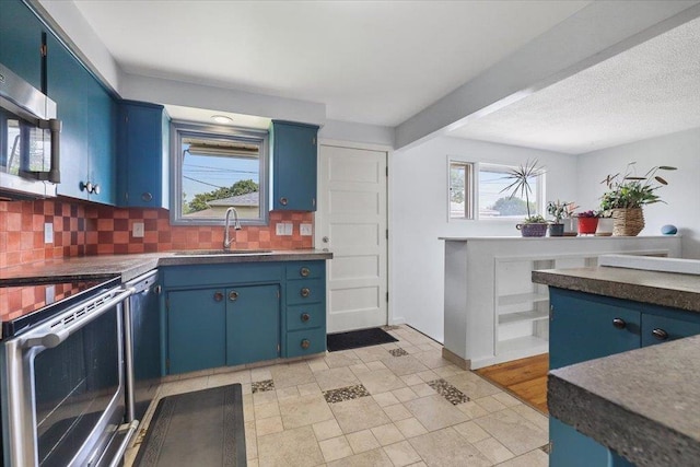 5318 N Walnut St, Spokane, WA 99205 - kitchen with blue cabinetry, stainless steel appliances, and backsplash
